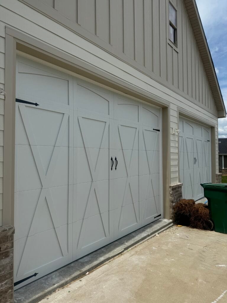 White carriage-style garage doors with X-brace design on a Lexington KY home