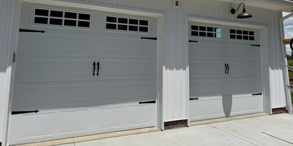 Gray carriage-style garage doors with windows, new installation