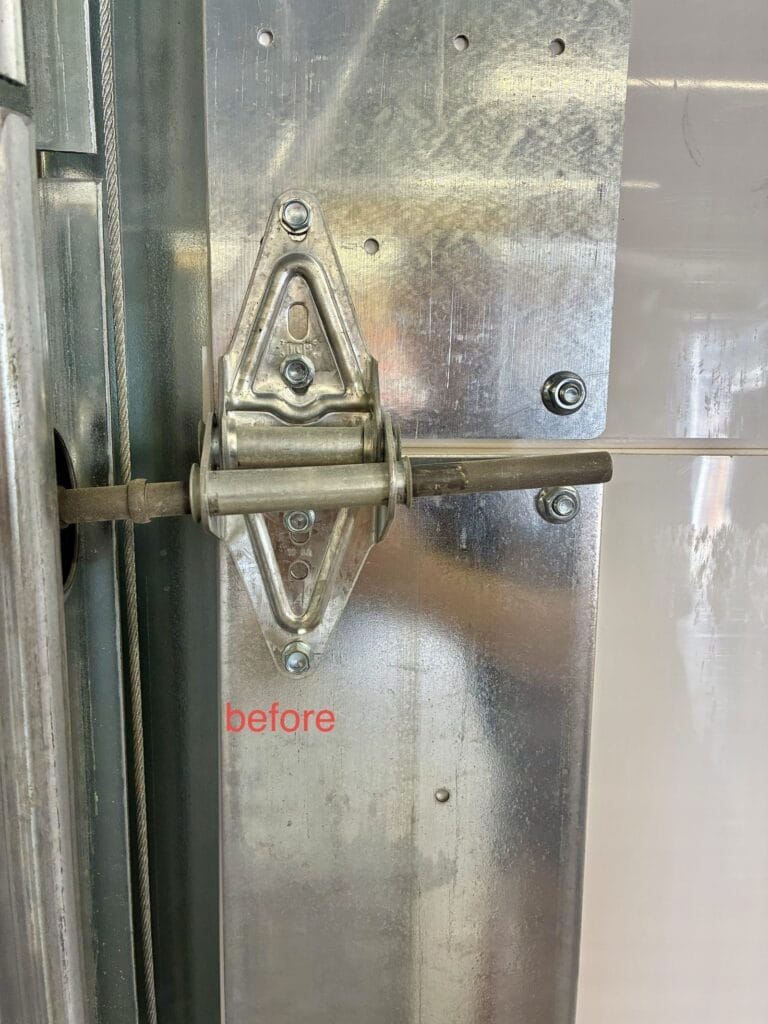Worn commercial door hinge before replacement