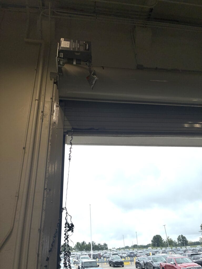 Commercial overhead door operator installed above a rolling steel door