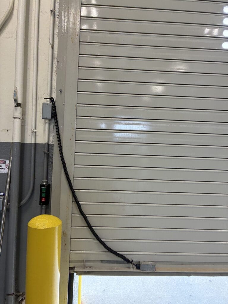Commercial rolling door with safety edge coil cord and three-button control station